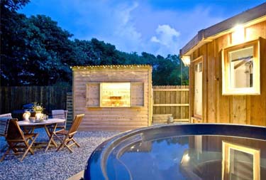 Exterior view with hot tub at East Thorne cottage in Bude, Cornwall