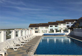 Swimming pool with lounge chairs at 34 Surfview Beach Cottage in Cornwall